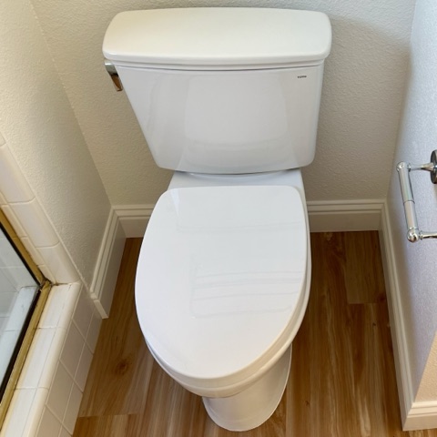 Toilet repair: a white two-piece toilet in a bathroom