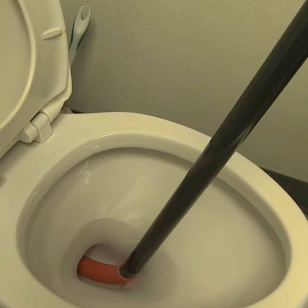 Toilet auger clearing a clogged toilet